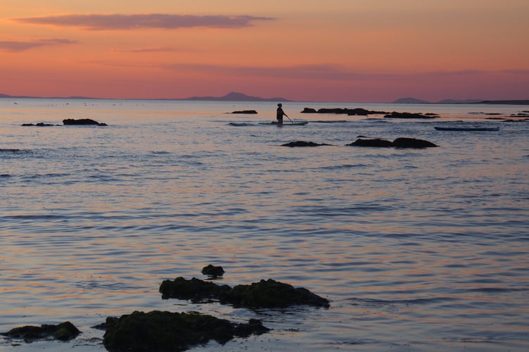 Margaret Pugnet caught this shot at dusk writing A paddleboarder enjoying an August sunset in Tywyn