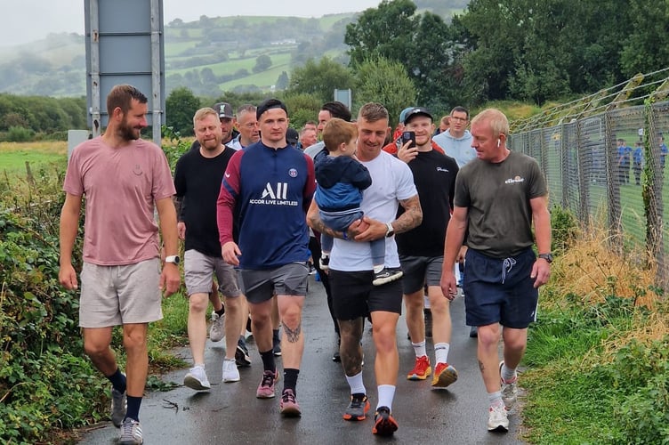 Andrew Gittins (in white) carrying his son on one of his laps