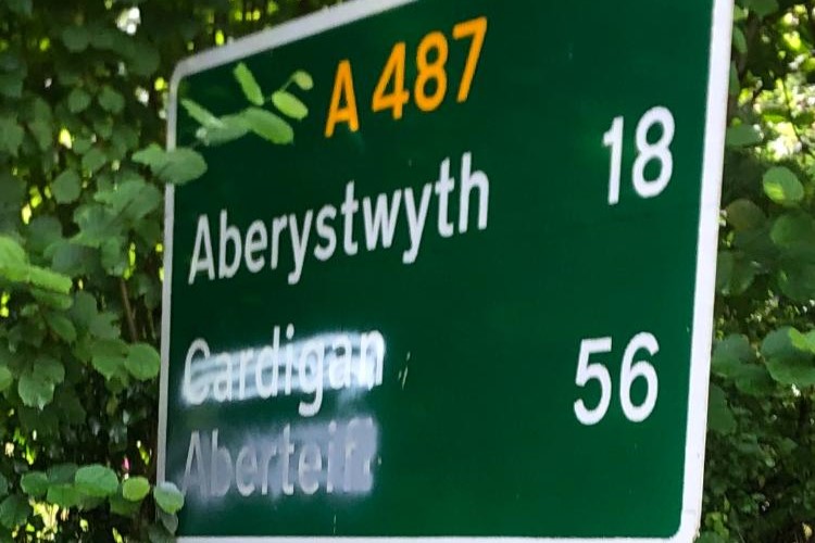 The long-graffitied crossing out of the 'Cardigan' place sign has recently been joined by the more confusing graffiti of 'Aberteifi' rendering visitors confused as to where Aberteifi could possibly be