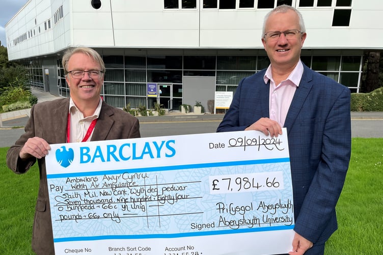 Mike May, Regional Funding Manager for Wales Air Ambulance being presented with a cheque by Aberystwyth University Vice-Chancellor, Professor Jon Timmis