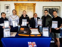 RNLI fundraisers in Aberaeron sign commemorative scroll
