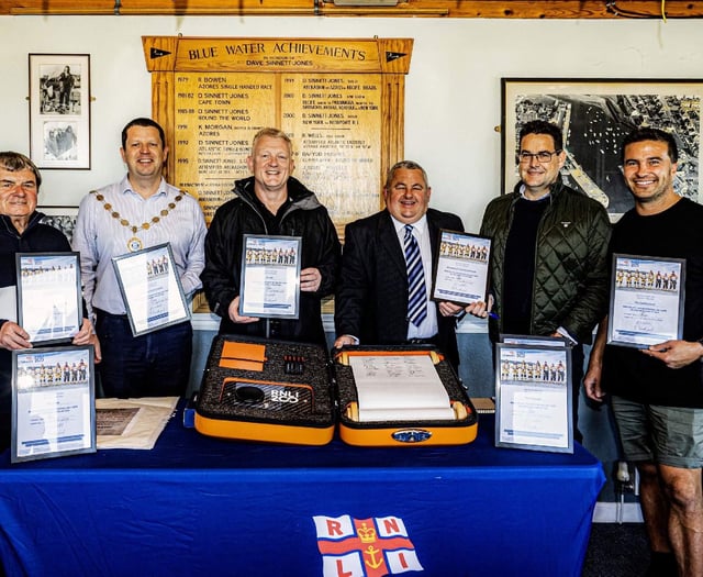 RNLI fundraisers in Aberaeron sign commemorative scroll