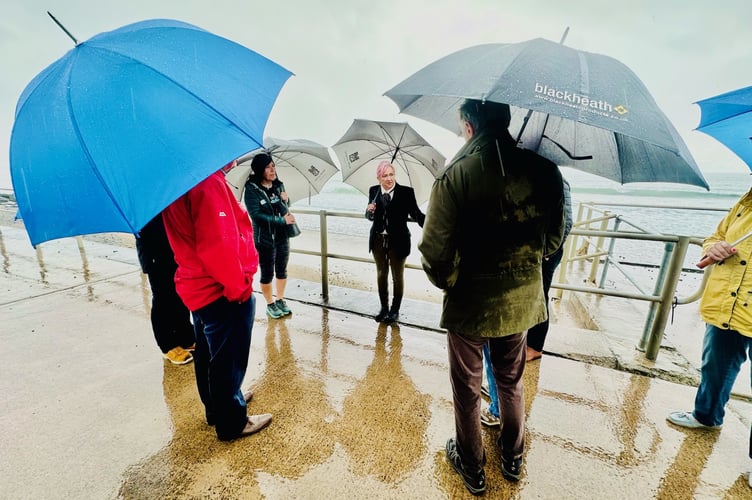 Leigh and Liz address Tywyn residents, councillors and businessowners about the state of the seafront. Leigh said the heavy rain was fitting for the discussion about crumbling sea defences.