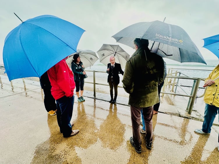 Leigh and Liz address Tywyn residents, councillors and businessowners about the state of the seafront. Leigh said the heavy rain was fitting for the discussion about crumbling sea defences.