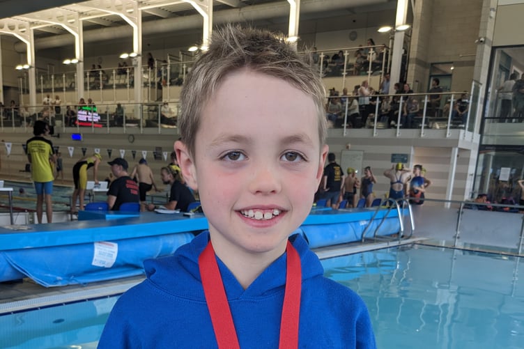 Young Owen Filmer from Yr Ysgol Gymraeg with his bronze medal in the 100m breaststroke