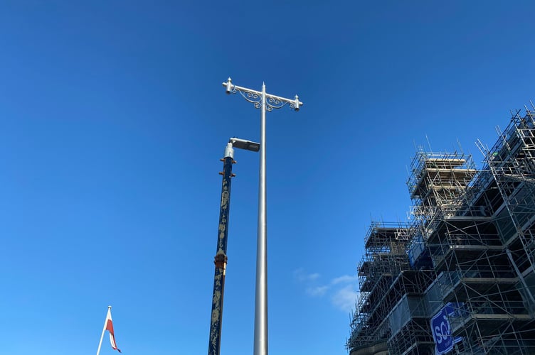 The new lamppost columns and heads by the Old College (in the foreground) and the former lampposts (in the background) being dismantled