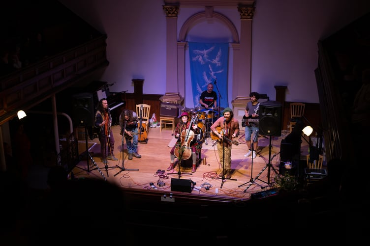 The Worldwide Welshman, Fairytale Cellist and others performing in front of Nicky Arscott's peace banner at the Big Gig for Gaza