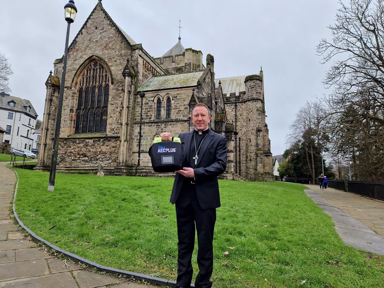 Bishop David with the defibrillator at Bangor Cathedral