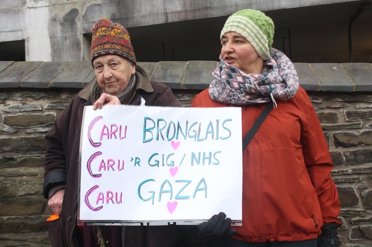 'Love Bronglais', 'love the NHS', 'love Gaza' sign held by two attendees of the protest outside Bronglais Hospital