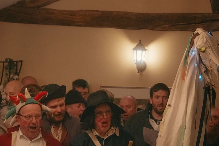 The Mari Lwyd singing pwnco with a group of men in 18th-century dress in the Brigands Inn, Mallwyd