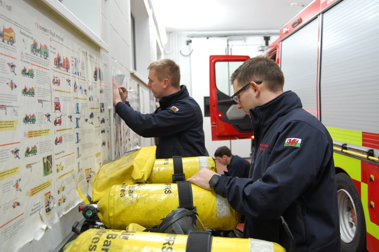 On-call firefighters checking the breathing apparatus on a drill night at Tywyn Fire Station