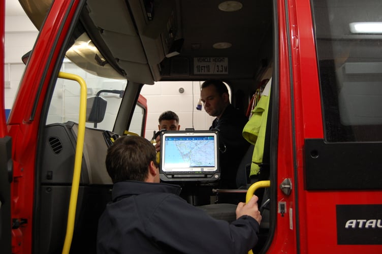 On-call firefighters checking equipment on the appliance (fire engine) during a drill night at Tywyn Fire Station
