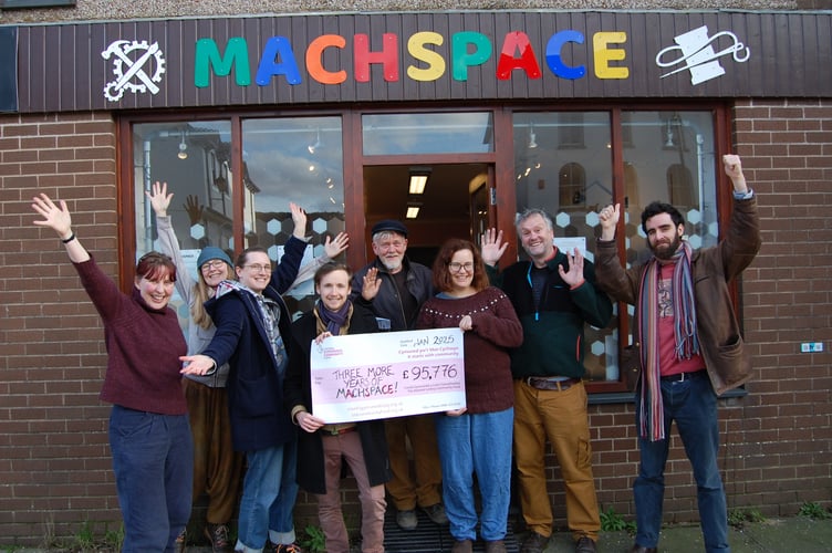 Machspace Directors and members holding a giant cheque outside Machspace on Penrallt Street in the town centre