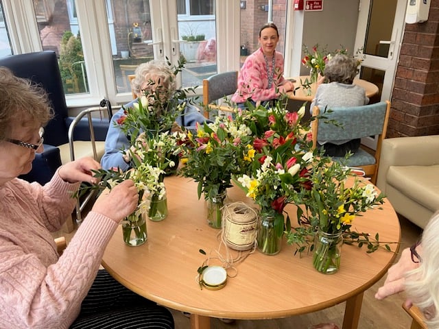 Residents arranging Dyfi Bunches to display around Cartref Dyfi