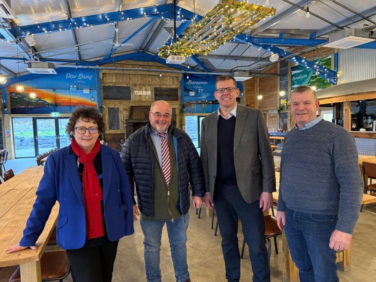 Elin Jones MS, Geraint Thomas, owner of the Moody Cow business, Rhun ap Iorwerth MS and Councillor Bryan Davies, Councillor for Llanarth Ward and Leader of Ceredigion County Council in the Moody Cow’s events room the Ysgubor