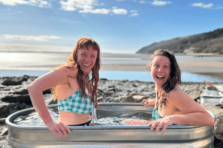 Two happy dippers in the cold plunge bath at Sawna Dyfi in Smugglers Cove Boatyard