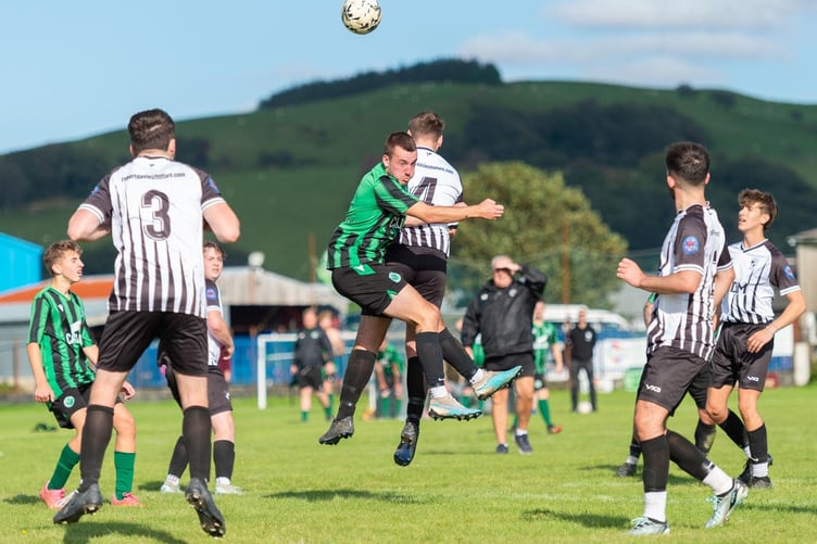 An aerial clash during Tregaron Turfs' 3-2 win at Rhayader on Friday evening