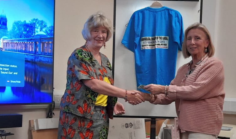 Mary Bowron hands Dr Margaret Morgan a collection from Inner Wheel members for Jan Jeffrey's work with disabled children in Lesotho