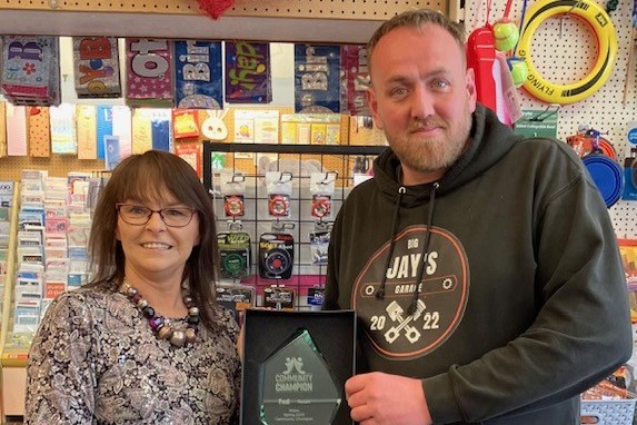 Trudy Davies and Jamie Squires at Woosnam & Davies News with the Spring Community Champion trophy received from The Federation of Independent Retailers