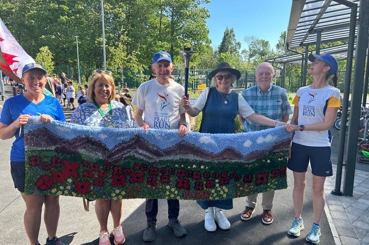 Criccieth Town Council Chair, Cllr Delyth Lloyd, Dr Catrin Jones, Council Clerk and Cllr Dr Peter Harlech Jones with some of the Peace Runners