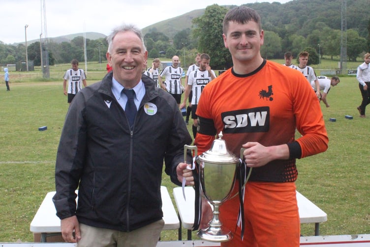 FAW council member Wyn Lewis presents the trophy to Forden captain Adam Clelow