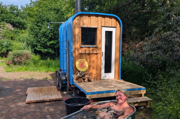 A happy customer in Sawna Dyfi's cold bath in their new location on the grounds of Plas Dolguog