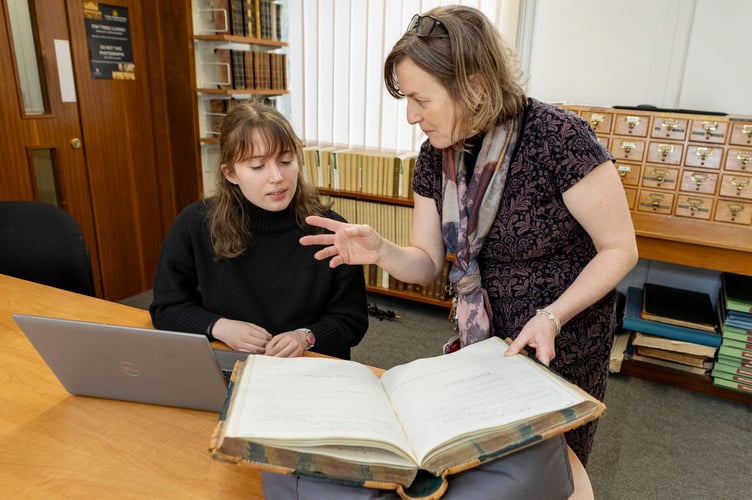 Elen Wyn Simpson shows a student one of the items held in Bangor Archives and Special Collections. Photo: Jill Jones, courtesy of Bangor Archives and Special Collection