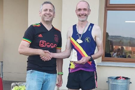 Longwood race organiser Rhys Burton presents men's winner Will Dunn with his awards