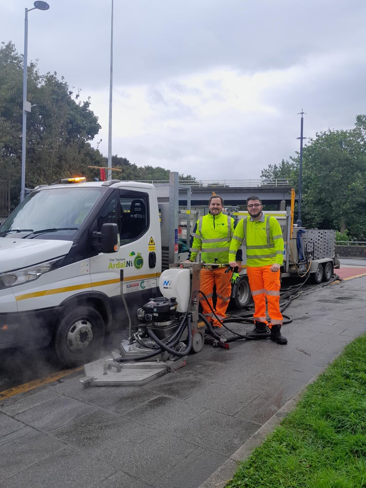 Members of the Timau Tacluso Ardal Ni – Justin and Dion – with the new machine cleaning the streets of Caernarfon. Photo: Gwynedd Council