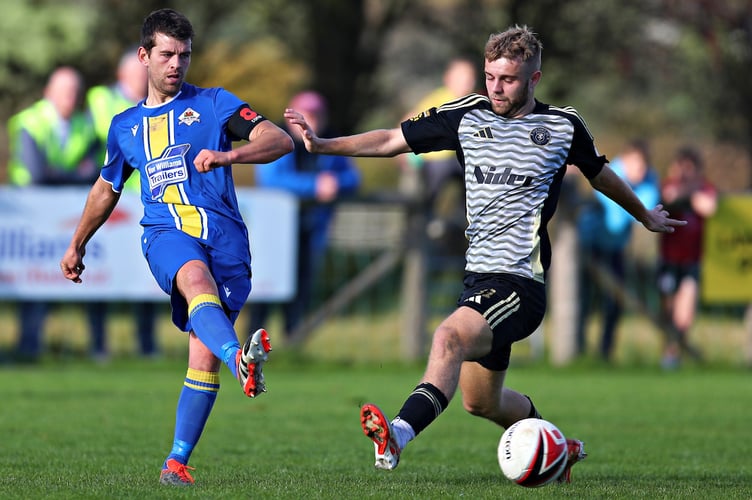 LLANUWCHLLYN, GWYNEDD, WALES - 19th OCTOBER 2024 - Llanuwchllyn's Ilan Hughes is pressured by Newtown's Ben Guest during CPD Llanuwchllyn vs Newtown AFC in Round 2 of the FAW Welsh Cup at the Village Hall, Llanuwchllyn (Pic by Sam Eaden/FAW)