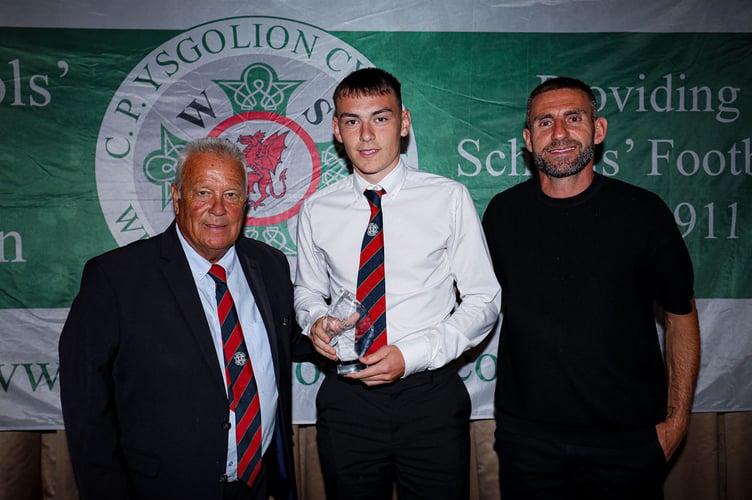 Coleg Meirion-Dwyfor student Osian Morris with his trophy for Most Improved Player, with Welsh Schools FA chairman Martin Evans and ex-footballer Angel Rangel