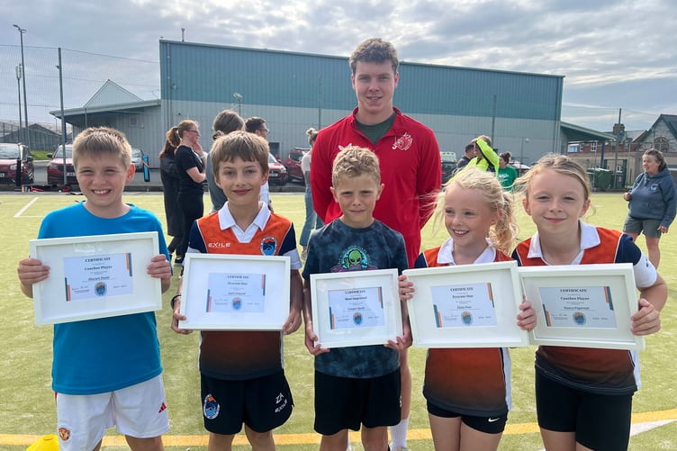 John Bennett (back) with 2025 Award Winners from Dysynni Hockey Club Junior Section. Left to right: Macsen Dunn, Zach Angood, Cooper Steele, Elain Puw and Nancy Papirnyk (missing from photo is Izzy Bird)