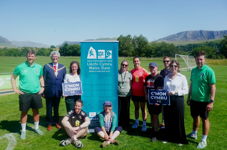 Peter Bridges, Head of Ysgol Llanllyfni on the left who organised the schools’ teams, with representation from Cyngor Gwynedd and the Football Association of Wales, noting the importance of the slate landscape in the day’s celebrations. Photo: Gwynedd Council