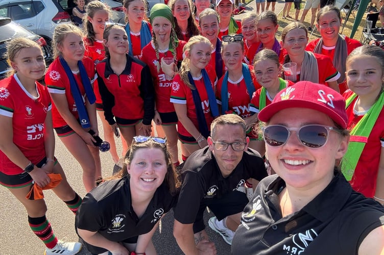 NW U13 girls with Dysynni Hockey club coaching team members Alice Bennett, Ryan Goddard and Pippa Rollings (Nel Pughe green headscarf, Evie Hodges with sunglasses and Polly Richards with black and red quarter zip top)
