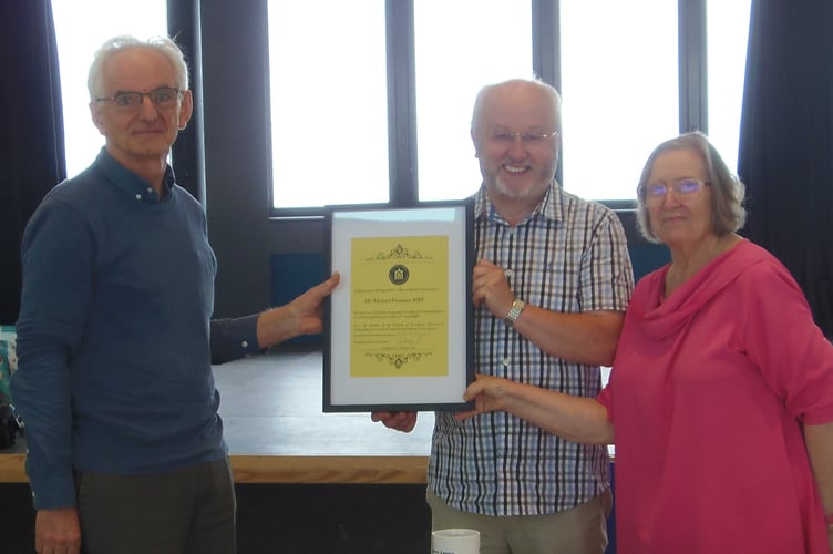 Michael Freeman MBE, left, receives his certificate from Cyril Evans, Chair of the Friends of Ceredigion Museum, and Bronwen Morgan, President of the Friends of Ceredigion Museum