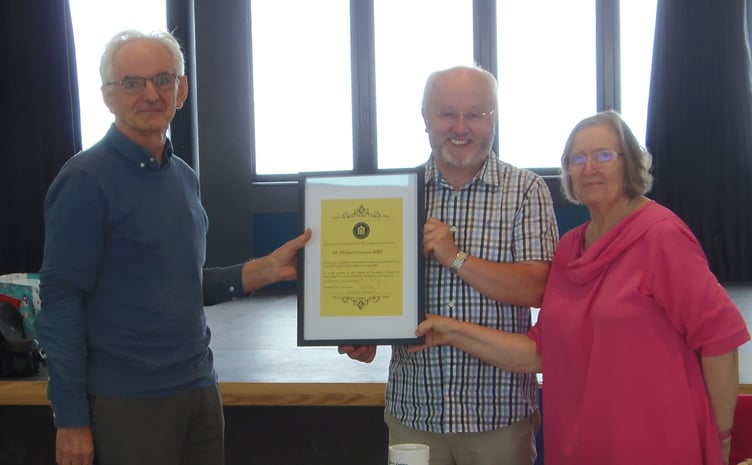 Michael Freeman MBE, left, receives his certificate from Cyril Evans, Chair of the Friends of Ceredigion Museum, and Bronwen Morgan, President of the Friends of Ceredigion Museum