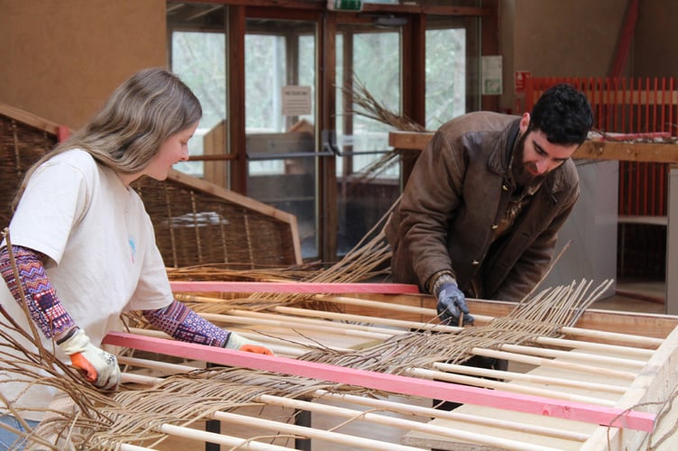 Throughout the build, students have had help from members of the CAT community and members of the local public with weaving willow using simple techniques to form the woven frames that are part of the roof of the structure. Photo: Centre for Alternative Technology