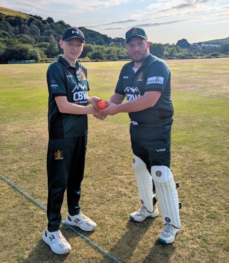 Dafydd Williams being presented with the match ball by captain Adam Shaw after claiming two wickets in his debut senior appearance for the club.