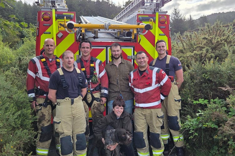 Aberystwyth Fire Station crew with rescued dog, Rusty, and his owners Cari and Owen. Photo: Aberystwyth Fire Station