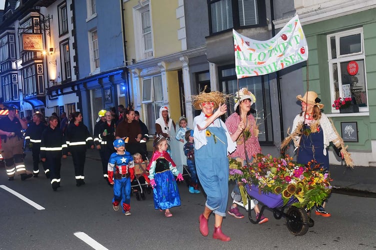 Aberdyfi 'Allotment by the Sea' lead some fire service members through the village. Photo: Doris O'Keefe