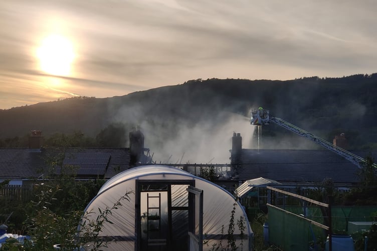 Firefighters can be seen tackling the blaze on Poplar Terrace, which has collapsed the roof of a home.