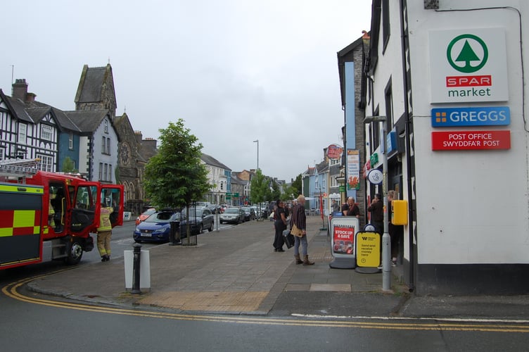 Staff waited outside the shop as a fire crew attended the scene. Photo: Cambrian News