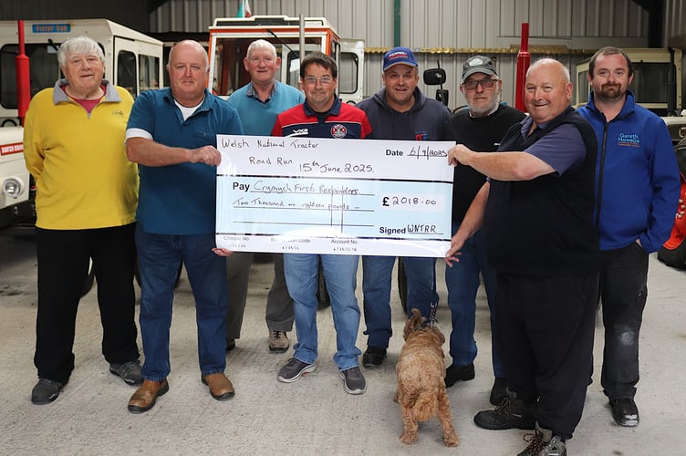 Glyn Vaughan of Crymych First Responders receive the cheque from WNTRR co-founder John Bates and the North Pembrokeshire Tractor Enthusiasts of Dai Rees, Alun Owens, Keith and Keith Evans, Sion Morgan and Peter Lewis.