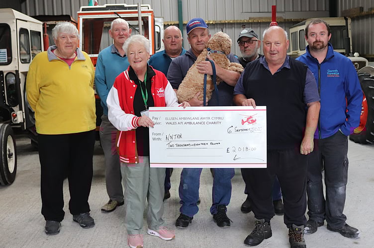 Ann Evans of Wales Air Ambulance receive the cheque from WNTRR co-founder John Bates and the North Pembrokeshire Tractor Enthusiasts of Dai Rees, Alun Owens, Keith and Keith Evans, Sion Morgan and Peter Lewis.