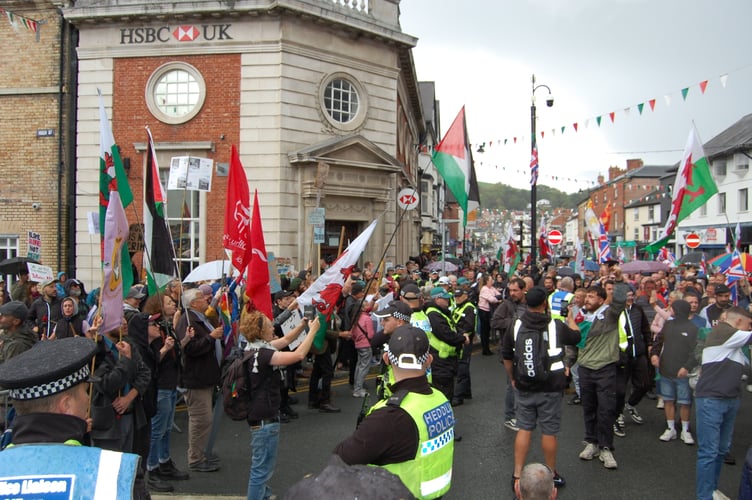 The two protest groups meet in Newtown on 13 September - (left) counter protest (right) anti-immigration protest, with police holding a line in between. Photo: Cambrian News