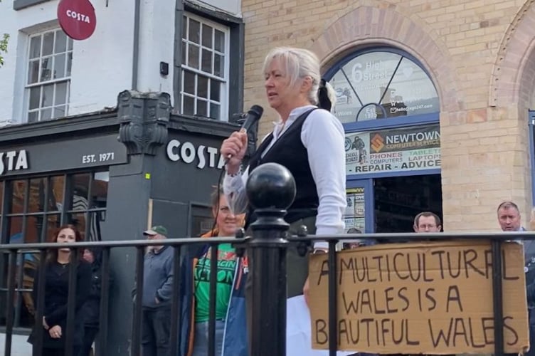 MP Liz Saville Roberts addressing the crowd in front of a sign that reads 'a multicultural Wales is a beautiful Wales'. Photo: Cambrian News