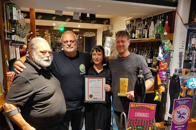 Chris Charters (left) and John Gale (centre) present the CAMRA Wales pub of the year award to Angharad and Paul Jacobs at the Rhos yr Hafod