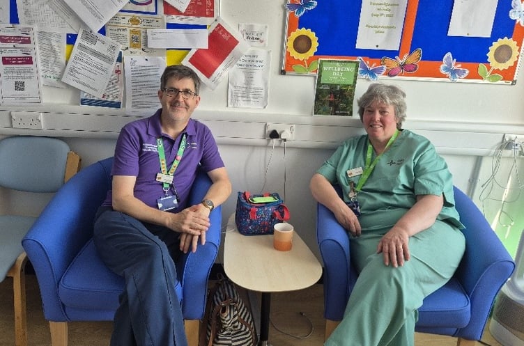 Paul Harries (Health Play Specialist) and Eleri Davies (Nursery Nurse) sitting in the new chairs