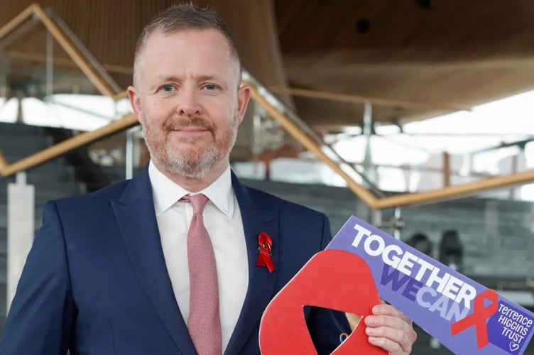Cabinet Secretary for Health and Social Care outside the Senedd with banner