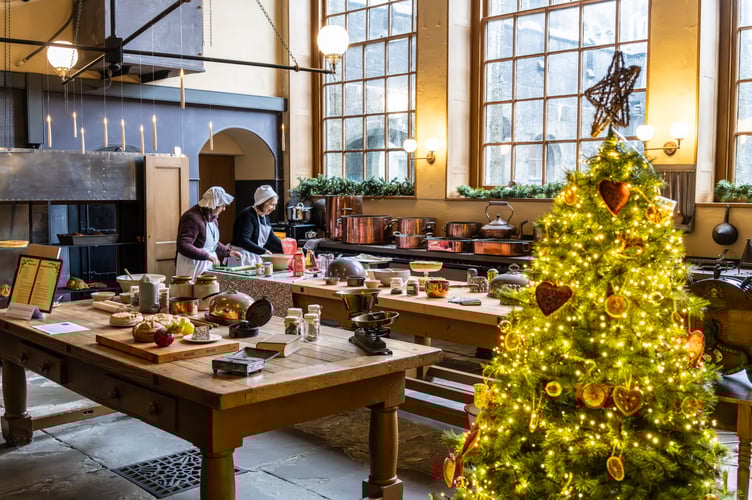 Volunteers in period costumes preparing Christmas cookies in the Kitchen at Penrhyn Castle and Garden, Gwynedd